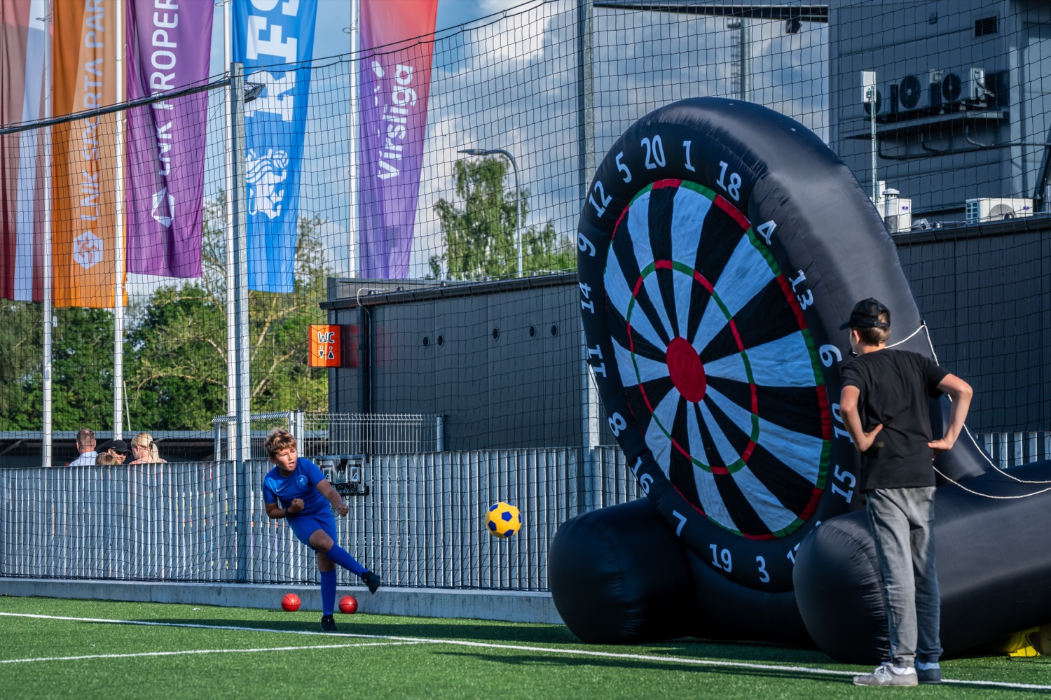 Zēns sper bumbu pa lielformāta futbola mērķi